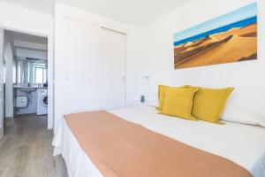 - une chambre blanche avec un grand lit et des oreillers jaunes dans l'établissement Home2Book Valle de Taurito, Sea Views & Pool, à Taurito