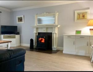 a living room with a fireplace with a fire in it at Springfield Holiday Home in Carndonagh