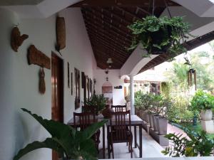 une salle à manger avec des tables, des chaises et des plantes dans l'établissement Embiente Guest House, à Negombo