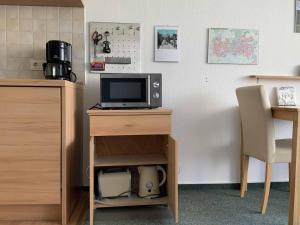 escritorio con TV y mesa con silla en Appartement an der Helenenquelle, en Bad Pyrmont