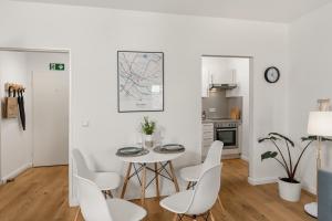 不莱梅MEL&BENS City-Apartment Domblick Marktplatz的白色的用餐室配有桌椅 更多7张照片