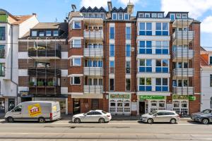 不莱梅MEL&BENS City-Apartment Domblick Marktplatz的一座高大的砖砌建筑,前面有汽车停放