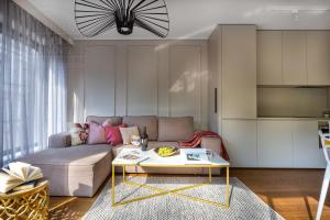 een woonkamer met een bank en een tafel bij Modern View of Planty Park in Krakau