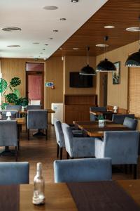 un ristorante con tavoli e sedie in legno, tavoli e una tavola di Kolobok a Luc'k