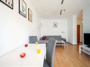 a living room with a white table and a couch at Waw Apartamenty Wilanów Branickiego in Warsaw