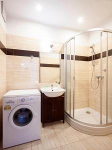 a bathroom with a washing machine and a shower at Waw Apartamenty Wilanów Branickiego in Warsaw