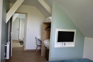 a bedroom with a bed and a tv on a wall at Le Carre Saint Pierre - Chambres d'hôtes in Marey-lès-Fussey