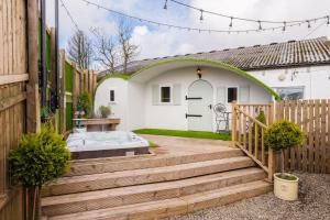 a backyard with a wooden deck and a white house at The Hobbit in Newmilns