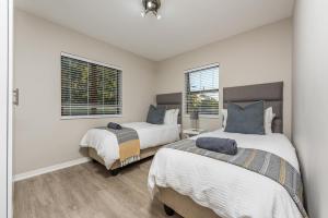 two beds in a room with two windows at Beacon Wharf , George Hay 5 Seafront Accommodation in Mossel Bay +25 photos