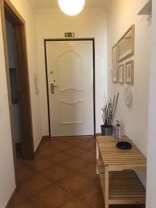 a hallway with a white door and a wooden table at PÉ NA AREIA by Stay in Alentejo in Vila Nova de Milfontes