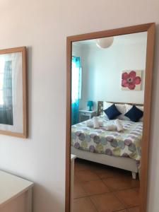 a bedroom with a bed and a mirror at PÉ NA AREIA by Stay in Alentejo in Vila Nova de Milfontes