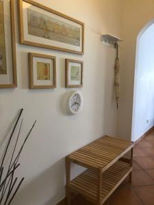 une chambre avec une table et une horloge sur un mur dans l'établissement PÉ NA AREIA by Stay in Alentejo, à Vila Nova de Milfontes