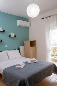 a bedroom with a bed with two towels on it at SeastheDayApartment in Nea Peramos