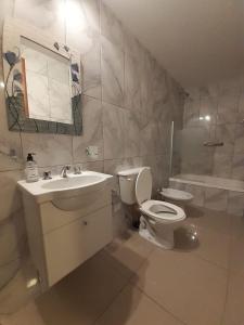 a bathroom with a toilet and a sink and a tub at Departamento Alem 2 en exclusivo Barrio Martin in Rosario