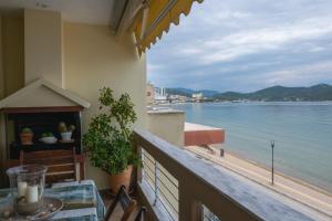 a balcony with a table and a view of the water at SeastheDayApartment in Nea Peramos