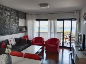 ein Wohnzimmer mit einem Sofa und roten Stühlen in der Unterkunft Vistas del Guadiana in Ayamonte