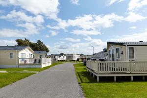 une route menant à une rangée de maisons dans l'établissement Golden Sands Holiday Park, à Kinmel Bay