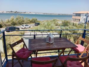 einen Tisch und Stühle auf einem Balkon mit Blick auf das Wasser in der Unterkunft Vistas del Guadiana in Ayamonte