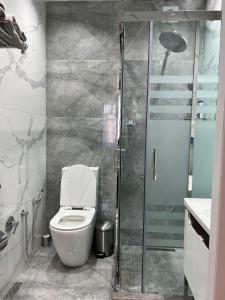 a bathroom with a toilet and a walk in shower at Seaside Luxury Apartment in Sumqayıt