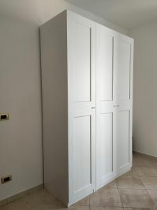 a closet with white doors in a room at Appartamento U scrusciu ro mari in Marzamemi
