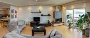 a living room with a couch and a fireplace at SeastheDayApartment in Nea Peramos