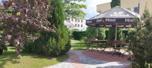 a patio with a table and chairs and an umbrella at Hotel Wanda in Kętrzyn