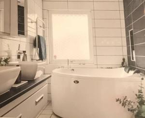 uma casa de banho branca com uma banheira e um lavatório em Wunderbares Feriendomizil mit Whirlpool em Sölvesborg