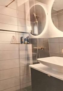 uma casa de banho com um chuveiro, um lavatório e um espelho. em Wunderbares Feriendomizil mit Whirlpool em Sölvesborg