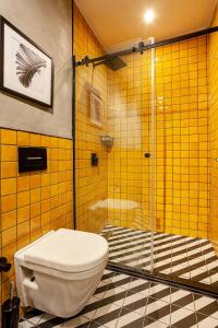 a yellow tiled bathroom with a toilet and a shower at World House Boutique Hotel Galata in Istanbul