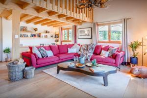 a living room with pink couches and a coffee table at Chalet Joux Verte - OVO Network in Les Gets