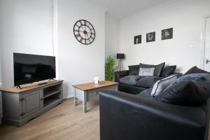a living room with a couch and a flat screen tv at Central Location & Spacious Family & Contractors & Free Parking in Derby