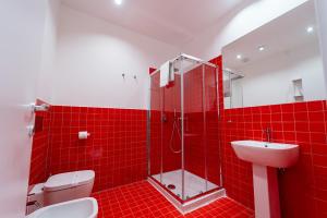 La salle de bains est pourvue de carrelage rouge, de toilettes et d'un lavabo. dans l'établissement P.C. Boutique Medina H. Napoli Centro, by Clapa Group, à Naples