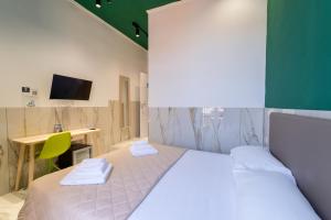 a bedroom with a bed and a desk with a monitor at P.C. Boutique Medina H. Napoli Centro, by Clapa Group in Naples