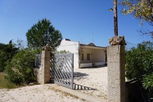 une porte menant à une villa avec une maison dans l'établissement Bivilla Incalzi, à Villanova di Ostuni