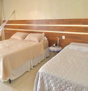 a bedroom with two beds and a wooden wall at FlatStudio05 na Nova Betânia - INNOVA in Mossoró