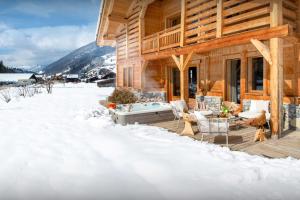 una cabaña de madera en la nieve en Chalet Ibusta - OVO Network, en Le Grand-Bornand