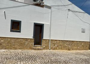 a white building with a door and two windows at Casa Arenga in Almádena