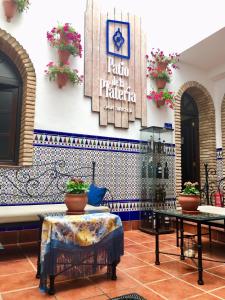 eine Lobby mit einem Tisch, einer Bank und einer Kachelwand in der Unterkunft Patio de la Plateria in Córdoba