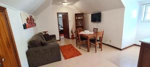 ein Wohnzimmer mit einem Sofa und einem Esstisch in der Unterkunft BBL APARTAMENTOS - B in Nazaré