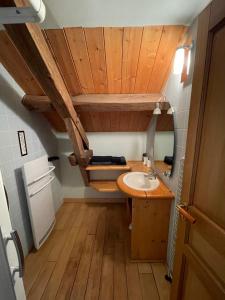 baño con lavabo y techo de madera en Le Moulin de cherré gîte bleu, en Aubigné-Racan