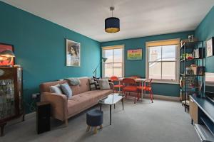 a living room with a couch and a table at Blackhorse Loft - spacious apartment by the sea in Deal