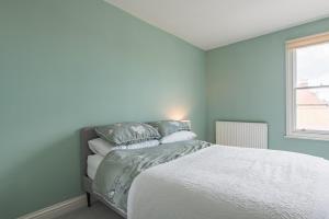 a bedroom with a bed and a window at Blackhorse Loft - spacious apartment by the sea in Deal