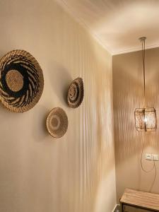 a wall with three wicker hats hanging on it at Athena Luxury Apartments in Mesongi