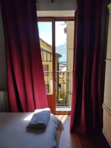 a bedroom with a red curtain and a large window at Hotel Palacio Branka in Mundaka