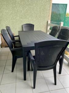 een zwarte tafel en stoelen in een kamer bij Pavillon à 400m de la plage avec piscine in Valras-Plage