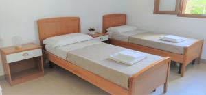 - 2 lits dans une chambre avec 2 tables de chevet et une sidx sidx dans l'établissement SUN LIGHT, à Tortolì