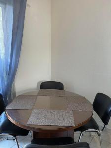 een tafel met stoelen in een kamer met een blauw gordijn bij Pavillon à 400m de la plage avec piscine in Valras-Plage
