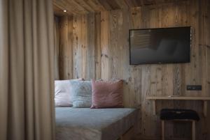 a bedroom with a television and a bed with pillows at Hotel Andermax in San Candido
