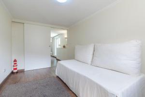 a white bedroom with a large bed with white pillows at Kochab Sintra by LovelyStay in Sintra