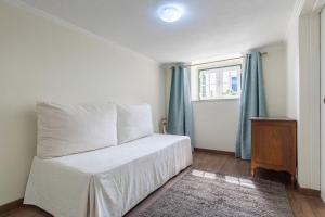 a bedroom with a bed with blue curtains and a window at Kochab Sintra by LovelyStay in Sintra